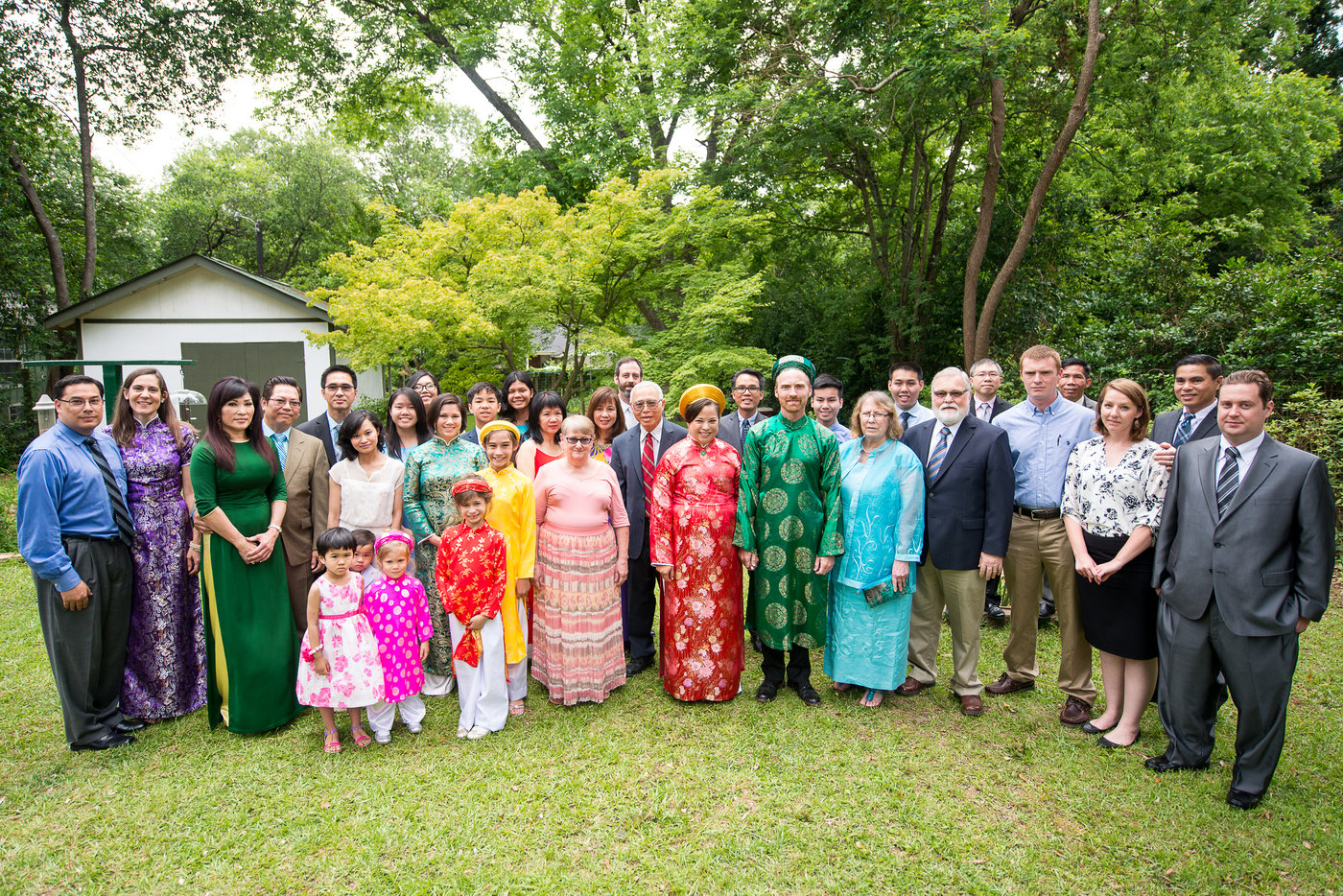 bride and groom with family in a green backyard