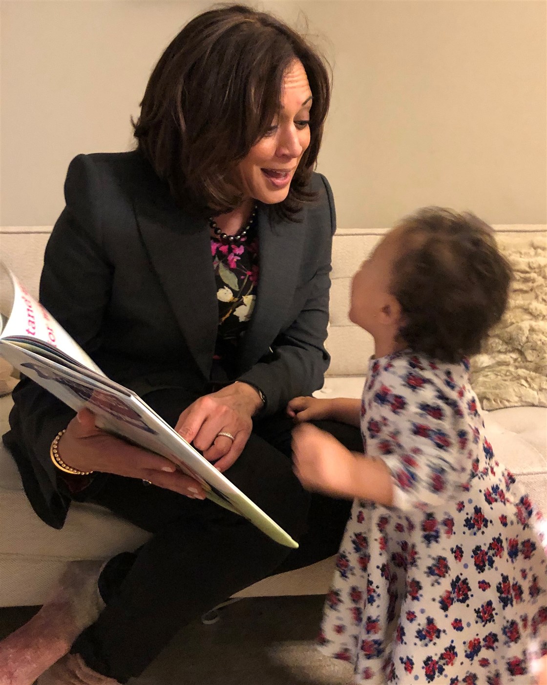 Kamala Harris sits and reads a picture book to her toddler niece