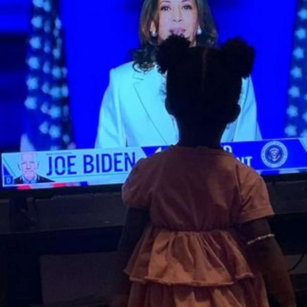 Very young, Black girl stands in front of her tv and watches Kamala Harris's victory speech