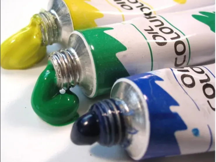 Oil paint tubes in blue, yellow, and green