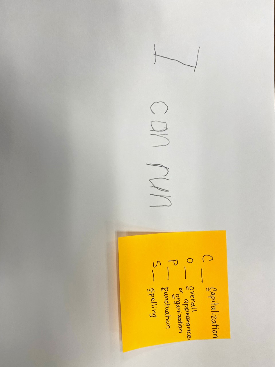 child's sentence with a sticky note of editing marks