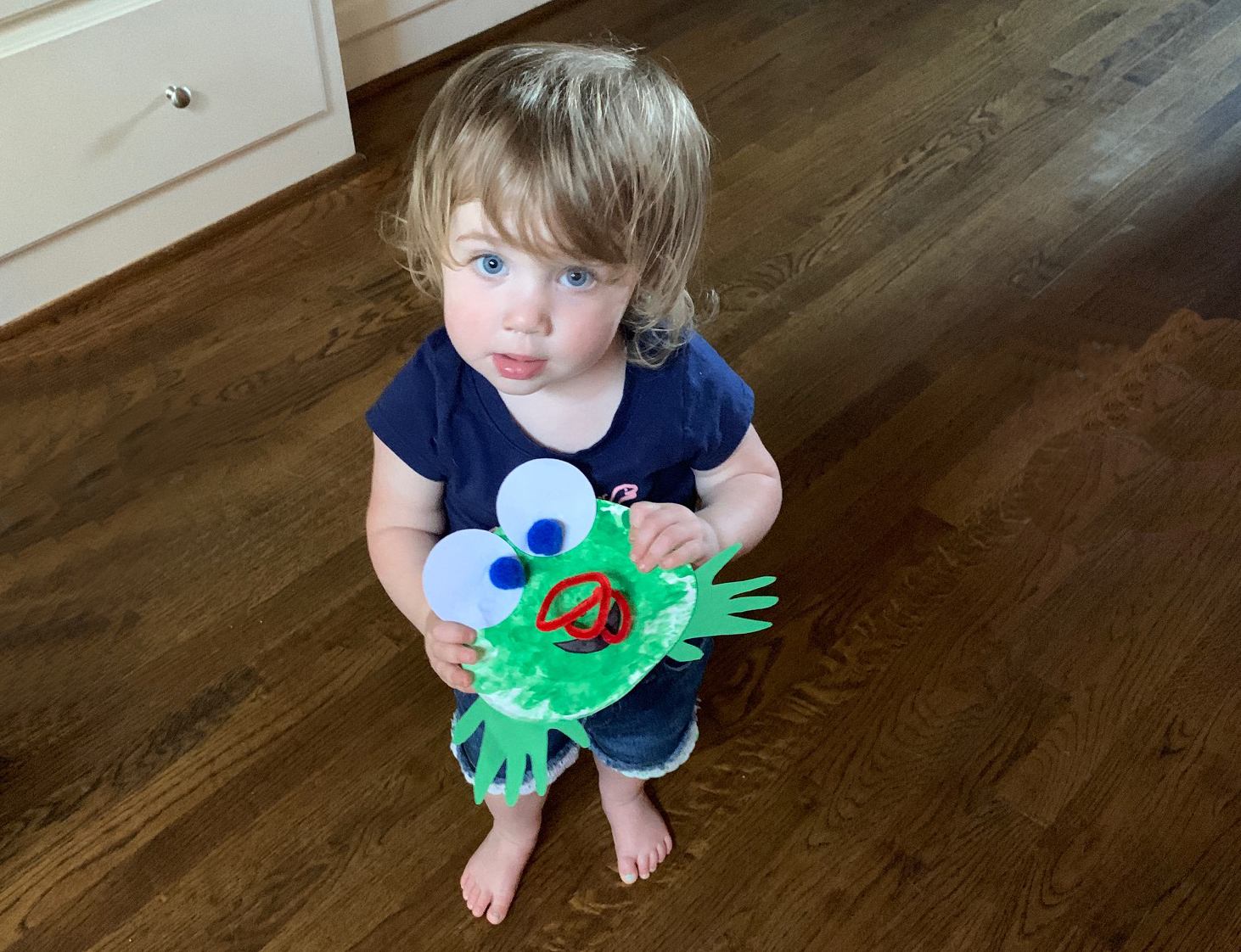 Child with completed frog craft