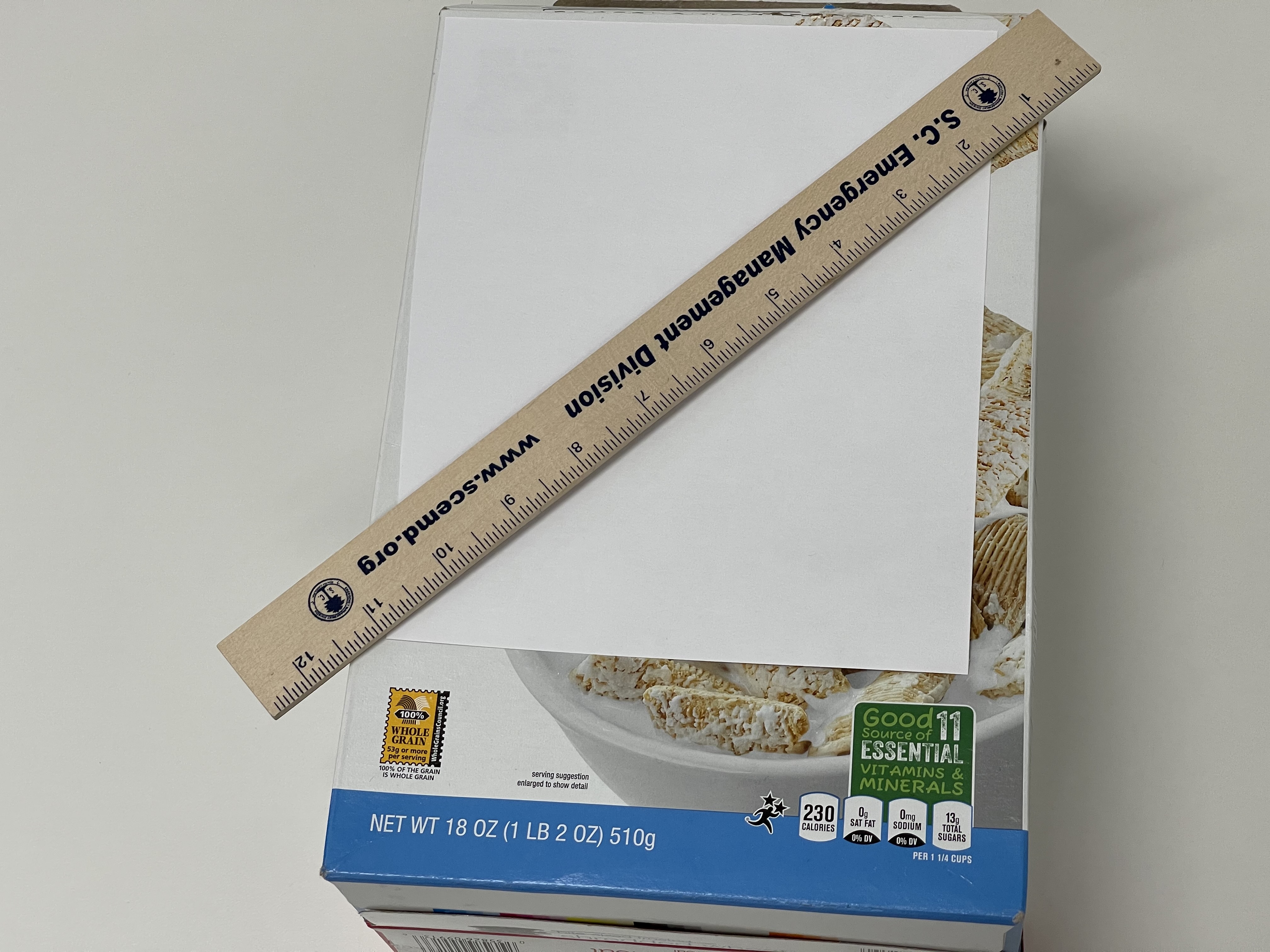 beige ruler lying diagonally on top of white cereal box