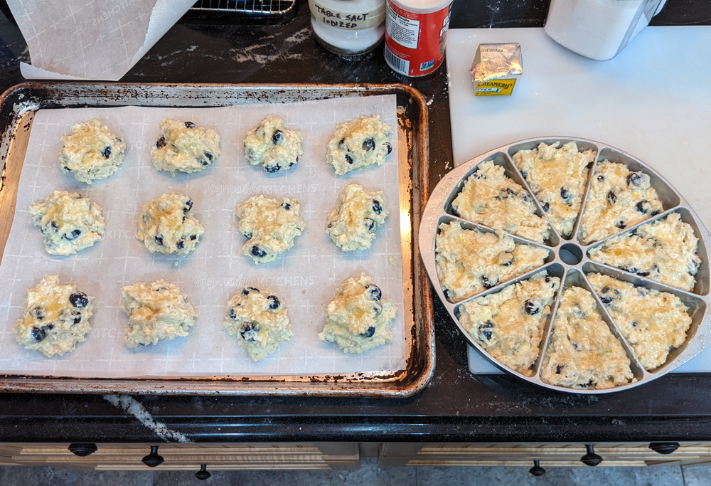 Photo: on the left is a baking sheet with drop scones and on the right is a scone pan - all with lemony blueberry scone dough