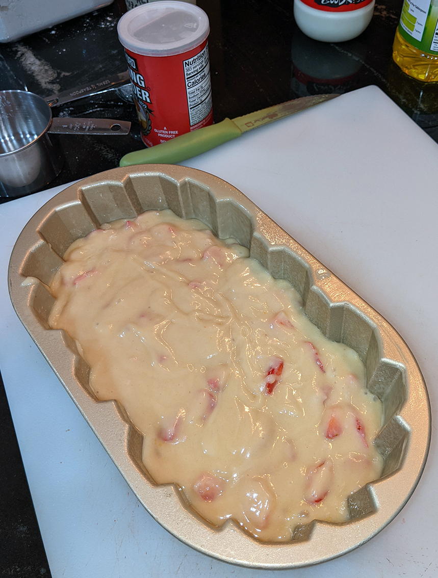Photo: a champagne colored braided loaf pan filled with the dough for strawberry bread