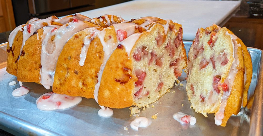 Photo: strawberry bread with one end sliced off; coated in a light glaze with strawberry bits in it