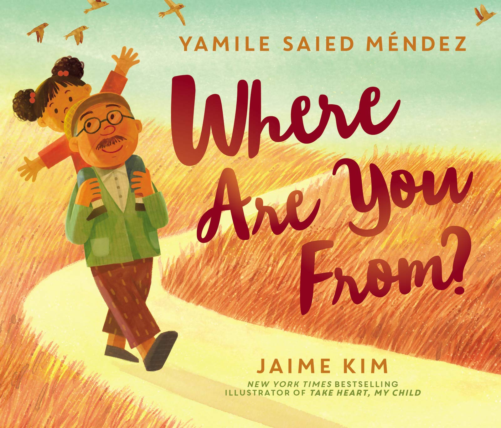 Cover of Where Are You From? features a grandfather walking on a dirt path with his granddaughter on his shoulders.  Fields of long, brown grass are on either side and birds fly into the sky.  The granddaughter looks happy and has her arms outstretched and her grandfather smiles.