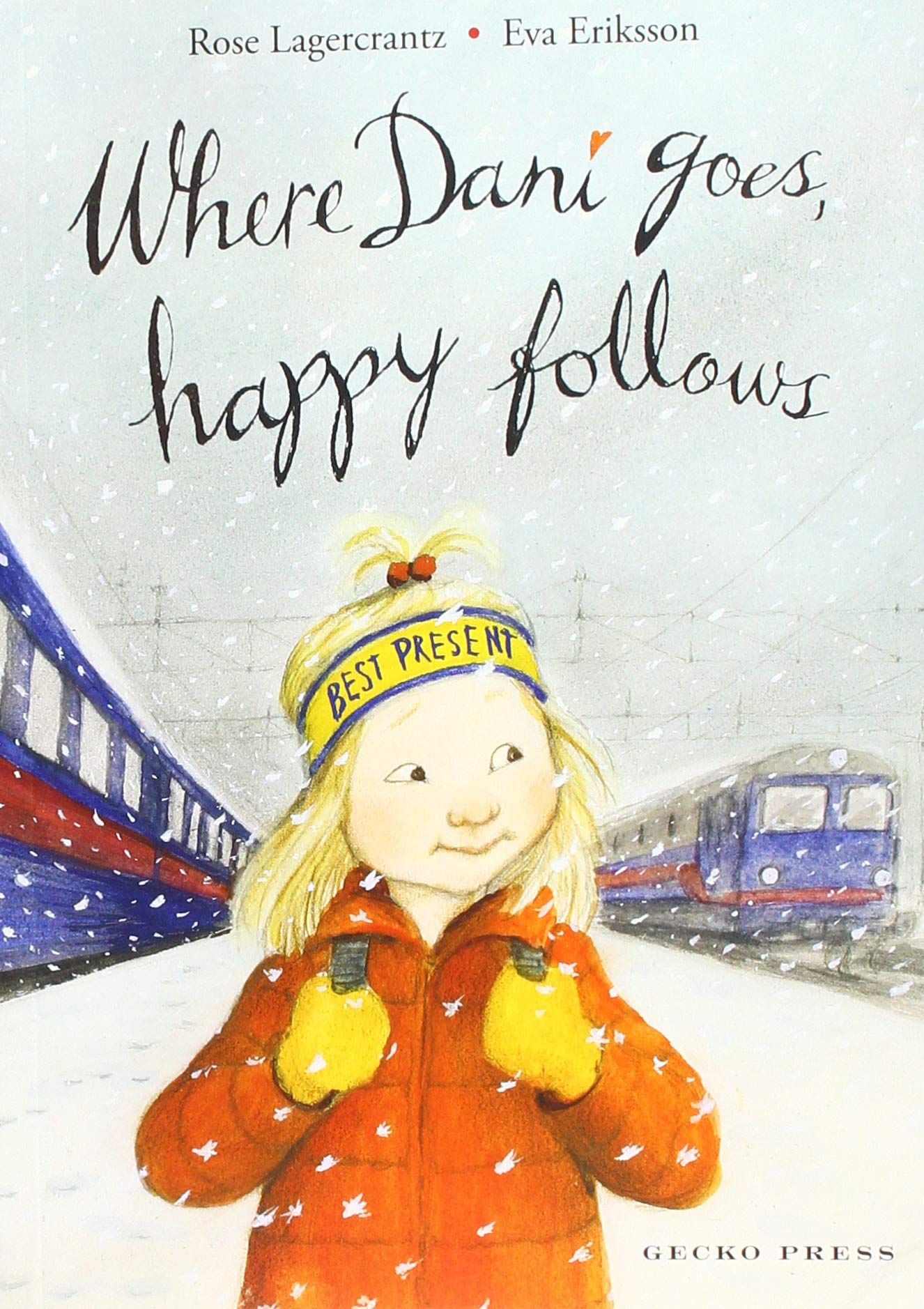 A young white girl is walking between two trains in the snow | She is blonde and wearing an orange jacket and yellow gloves and clutching the straps of her backpack. | 