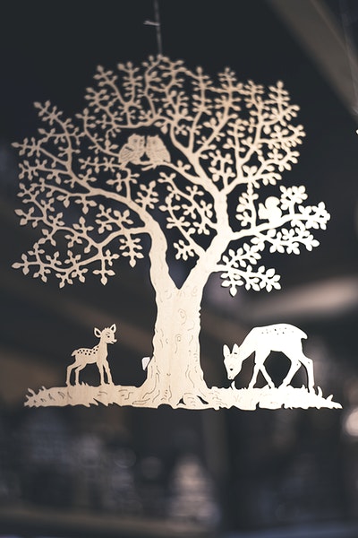 A silver ornament of a tree with woodland animals