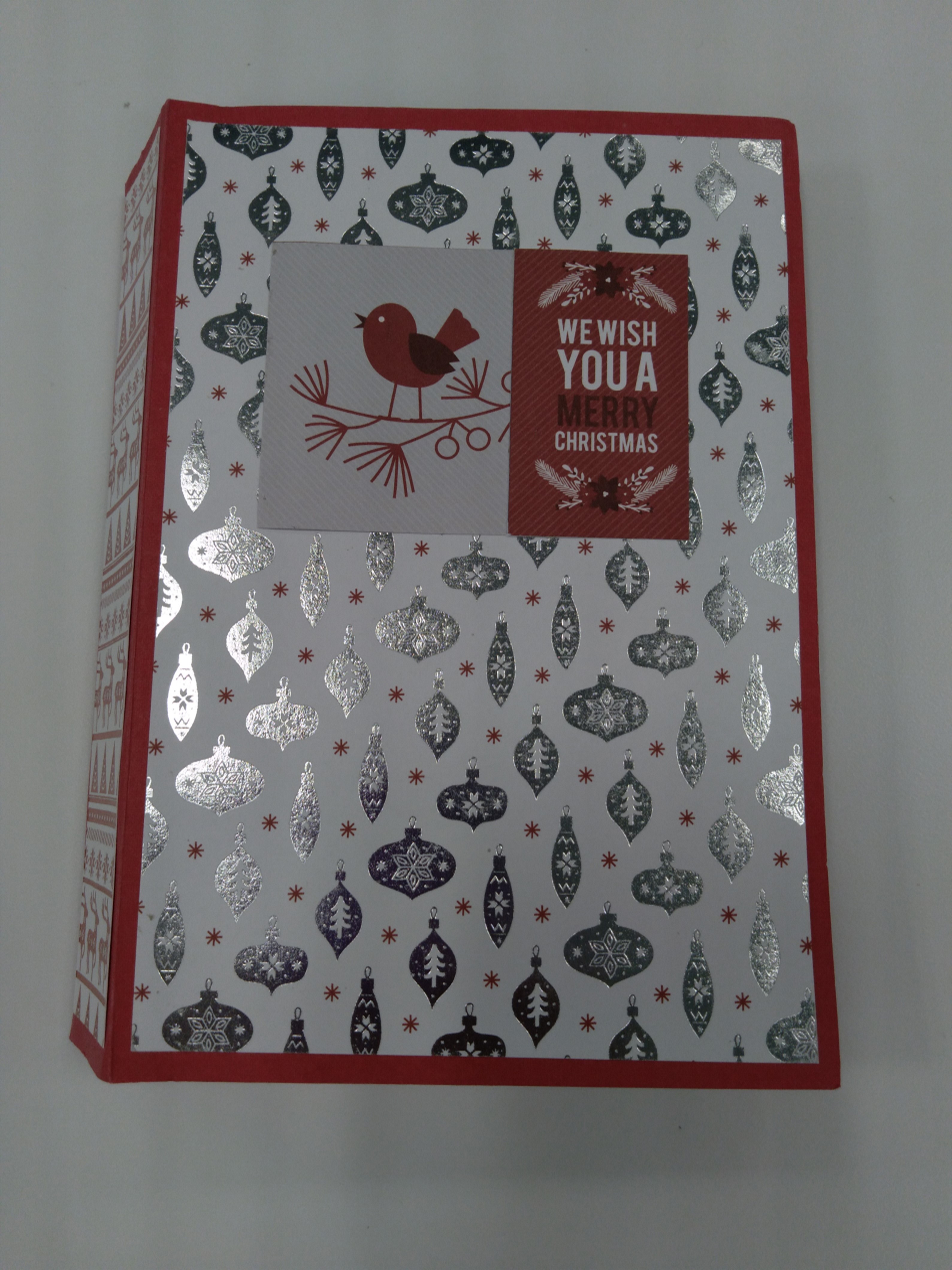 mini album with white background and silver ornaments on the cover. Text reads "we wish you a merry Christms"
