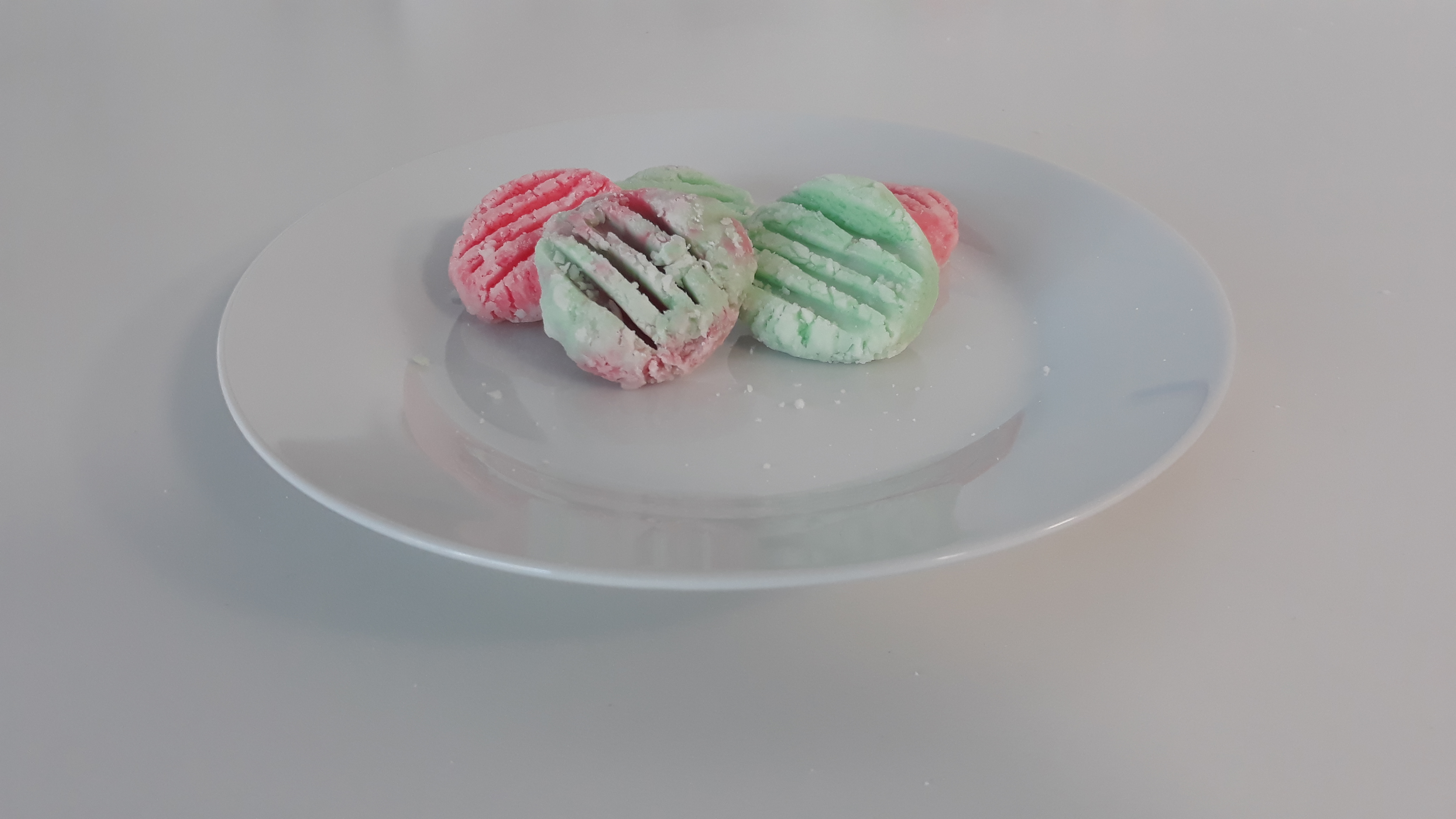 Red and green mints arranged on a white plate