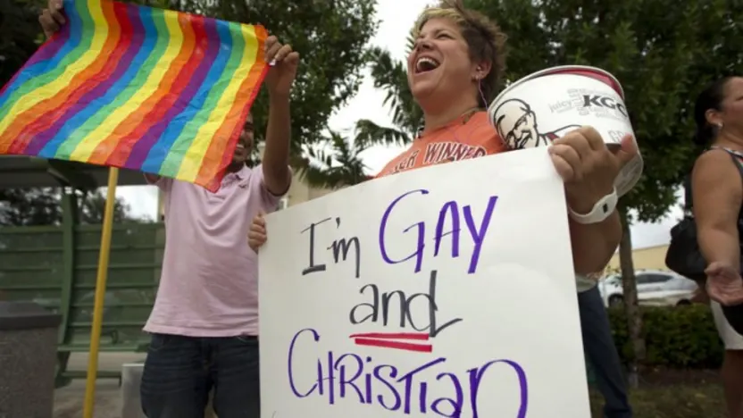 person with sign that says "I am gay and Christian"