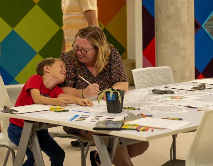Mother and son sit at table for arts and crafts.