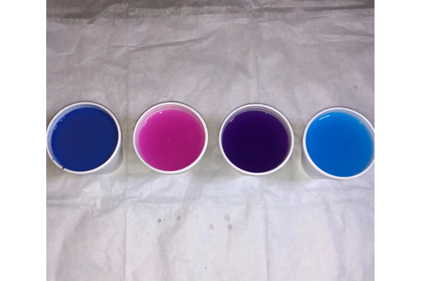 Four cups of paint (periwinkle, pink, purple, and blue)