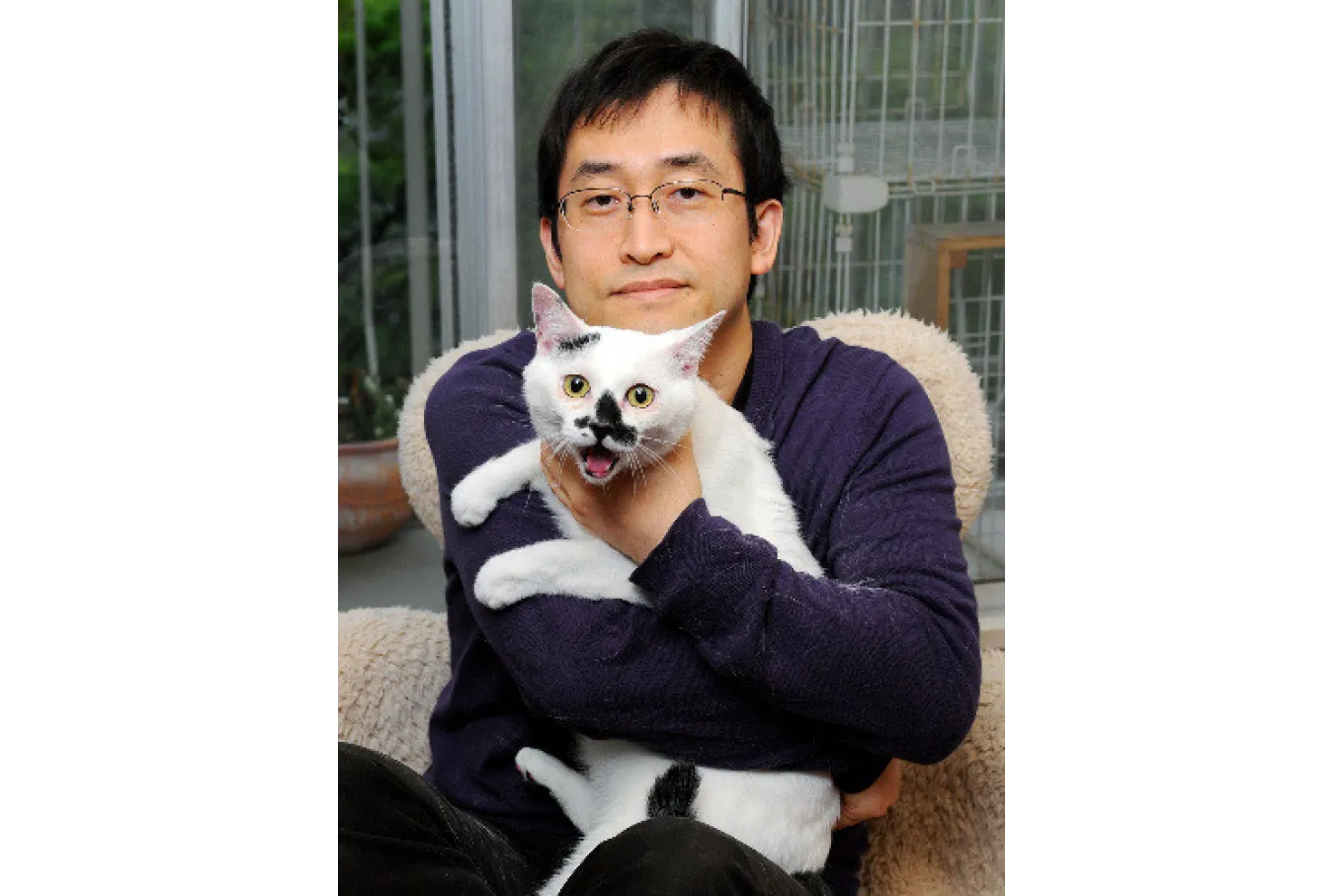 Horror manga artist Junji Ito posing with his cat.
