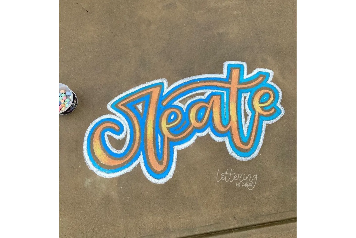 Chalk art of the word "create" in yellow, blue, and white