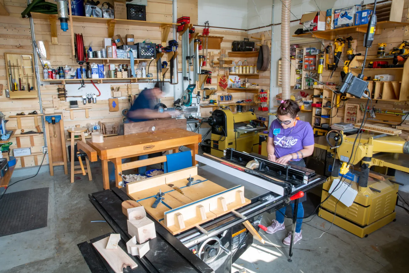 Two staff members--one male, one female--work on projects in the Fabrication Studio