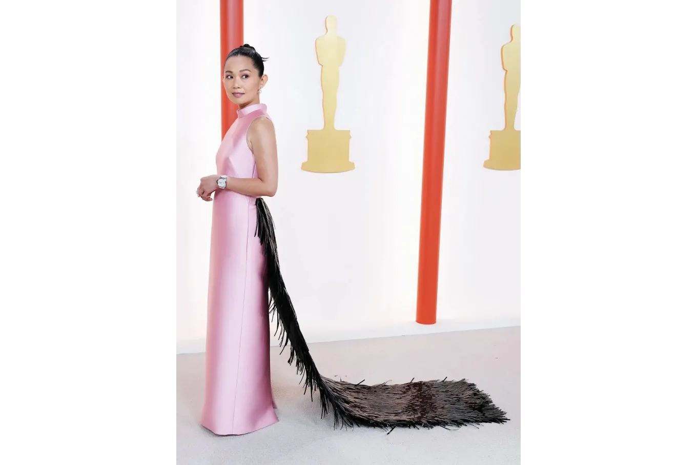 actress Hong Chau wearing a pink sheath dress with black train