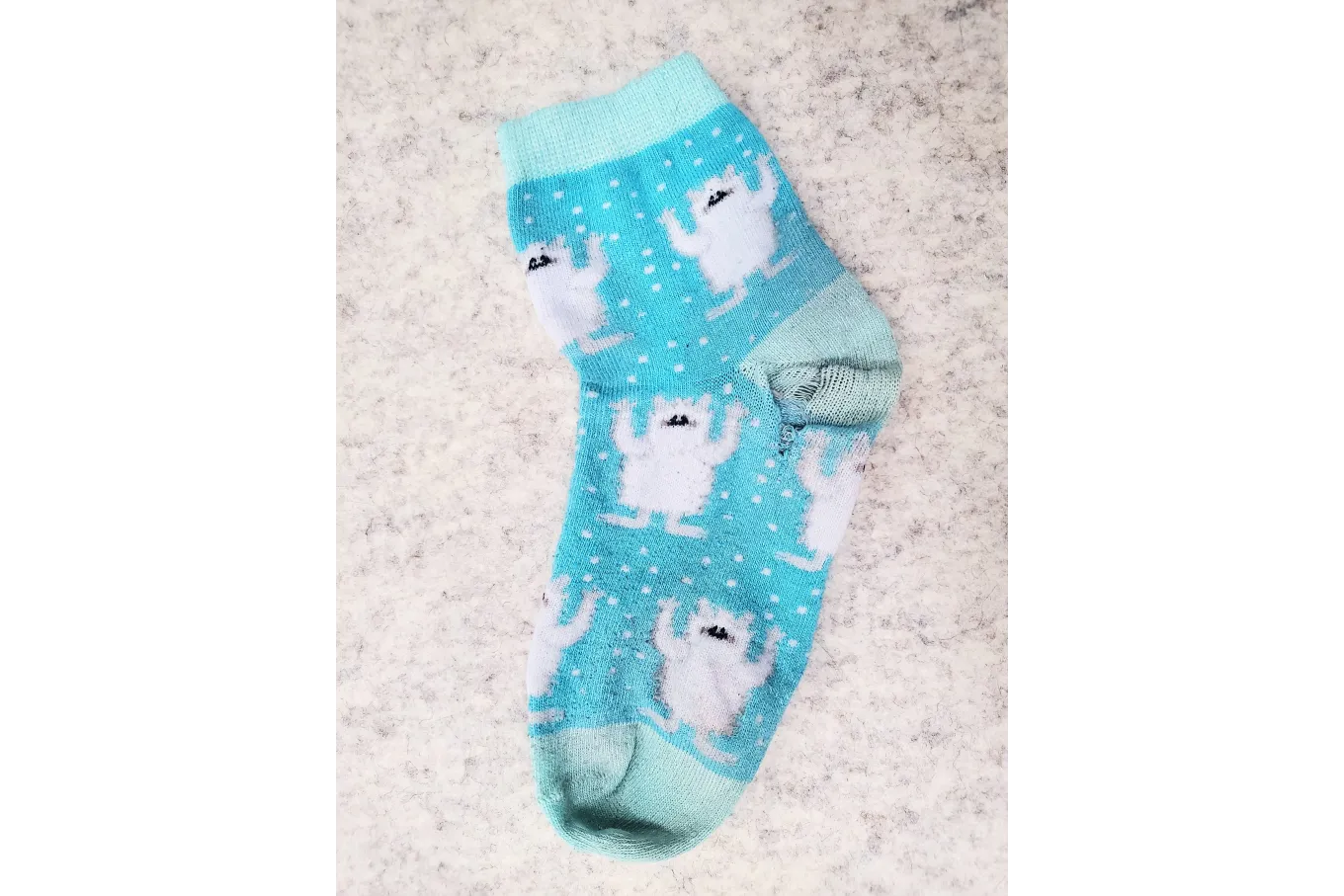 Baby blue polyester socks with yeti print and a hole in the heel
