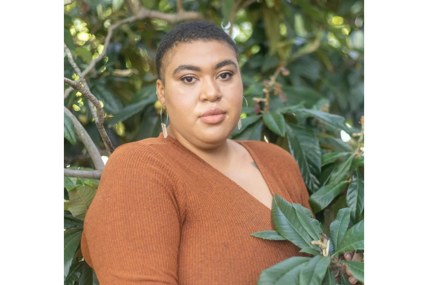 Blooms, D. Headshot, amongst greenery, clothed in brown attire