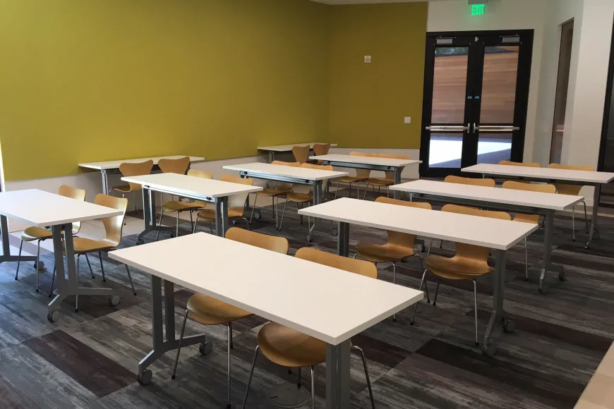 large room with 10 tables, 20 chairs, projector with screen