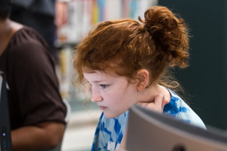 Teen girl sitting at desktop computer