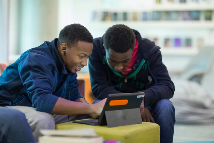 Teen boys looking at a tablet.