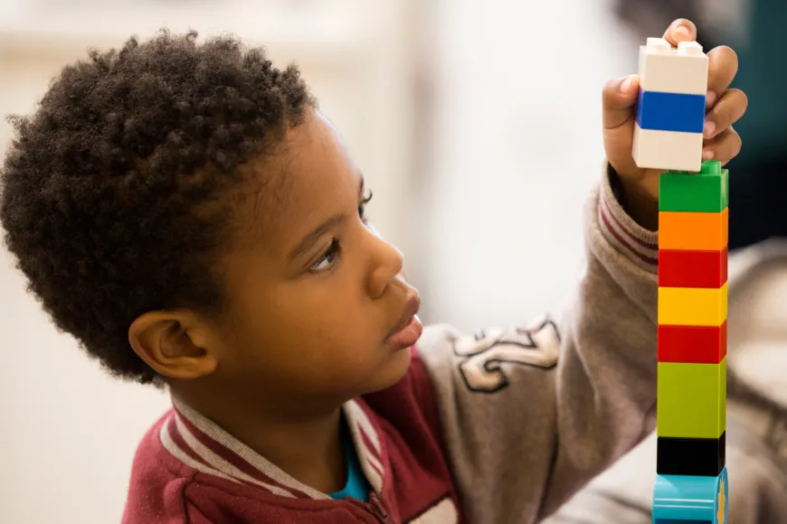 Boy building lego tower.