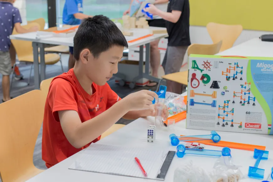 Boy building marble track.
