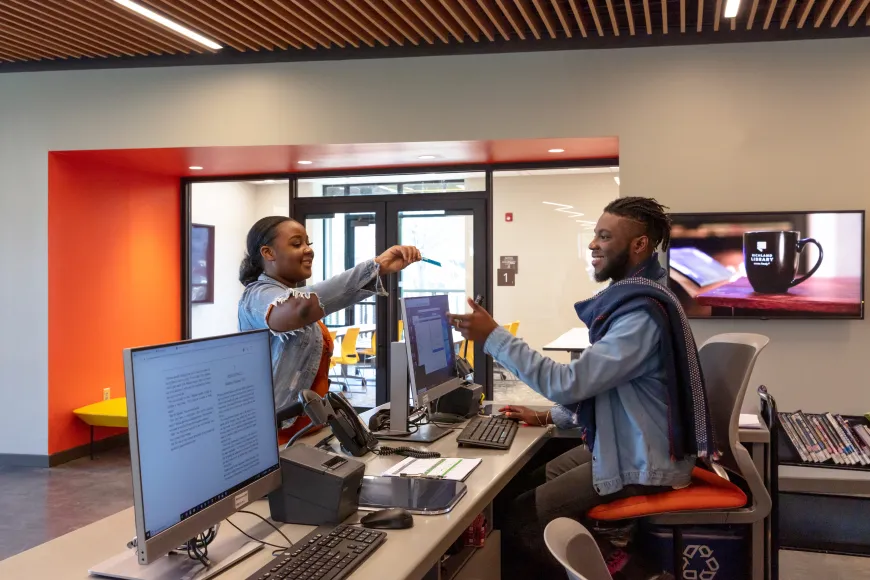 A customer checking out using her library card at the Edgewood location