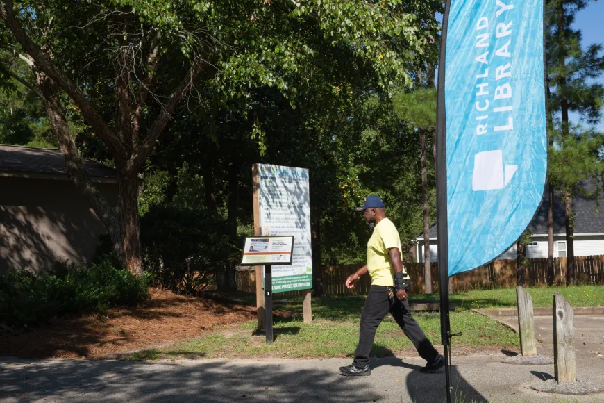 Man walks past StoryWalk at Caughman Road Park in Hopkins