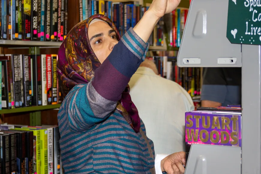 Woman pulls item from shelf at book sale