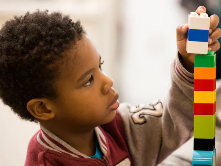 Boy building lego tower.