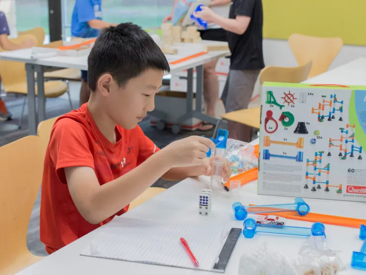 Boy building marble track.