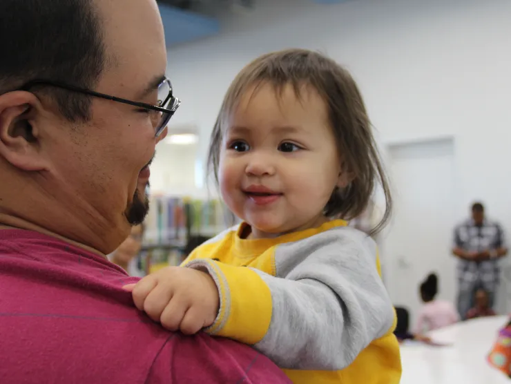 Baby looking over male shoulder