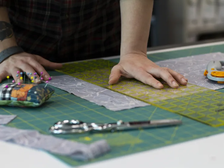 white female hands cutting fabric