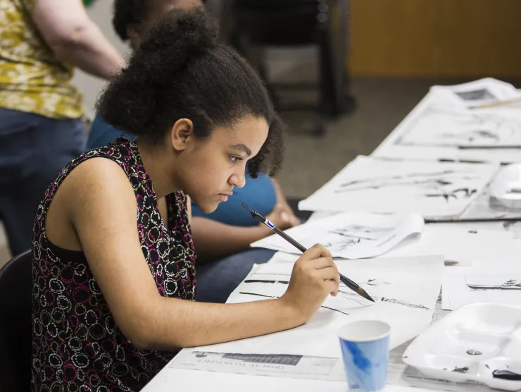 Teen girl learns how to create Chinese brush paintings at Richland Library