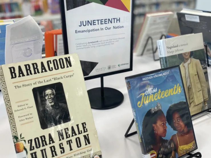 Juneteenth flyer on stand with three items surrounding it. Blurred background.