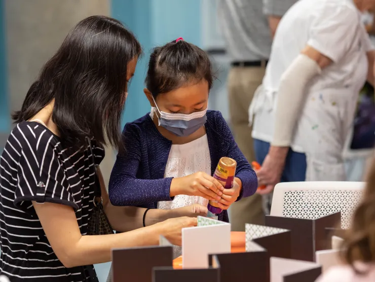 Adult and child work on a craft at Richland Library Main