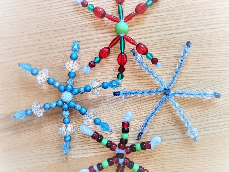 Four bead-and-pipe cleaner snowflakes. Two blue and silver, two green and red