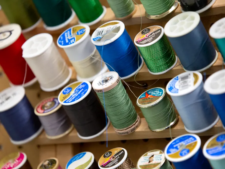 Multi-colored spools of thread in rows