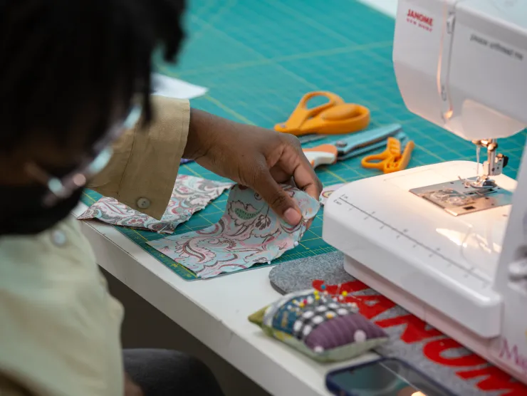 Black female works on sewing machine at Richland Library