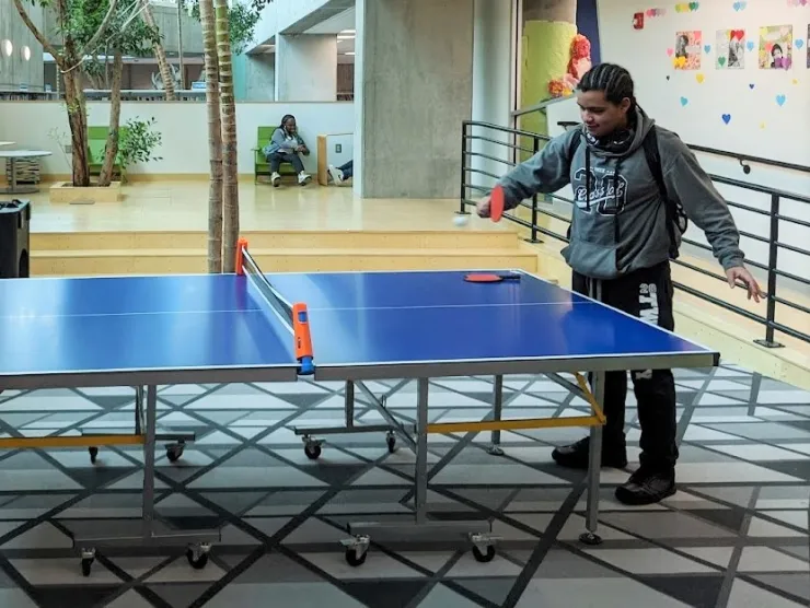 Teen hitting a table tennis ball in the Teen Center