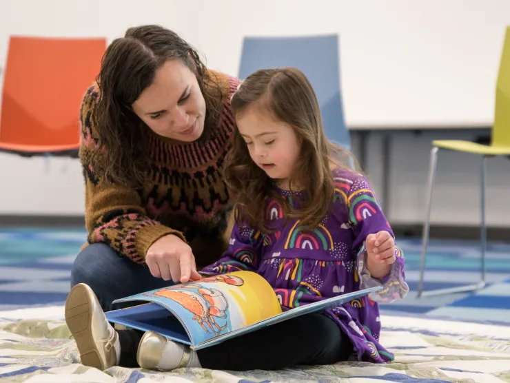 Mom and daughter reading together on the floor 