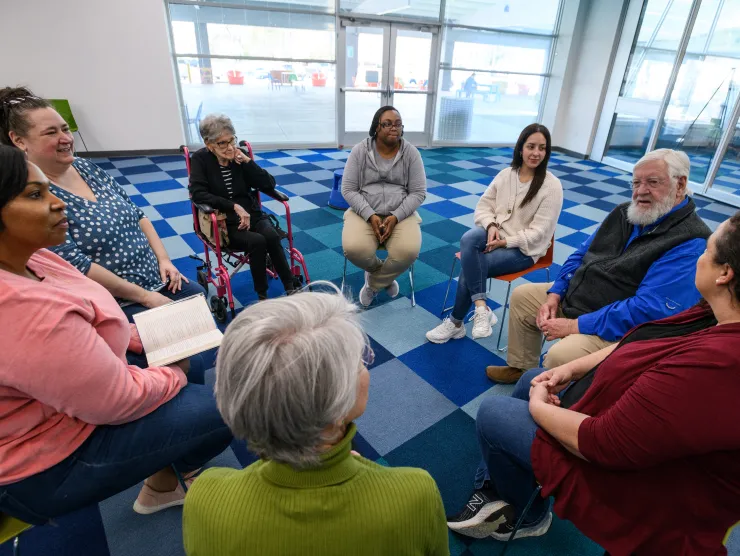 Book Group meets in a circle, holding books in their lap