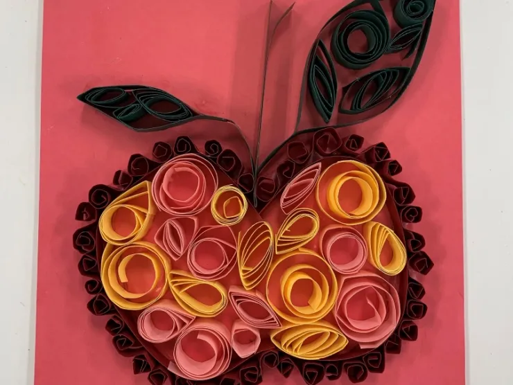 Photo: an apple made of quilled paper (paper that has been rolled into various shapes)