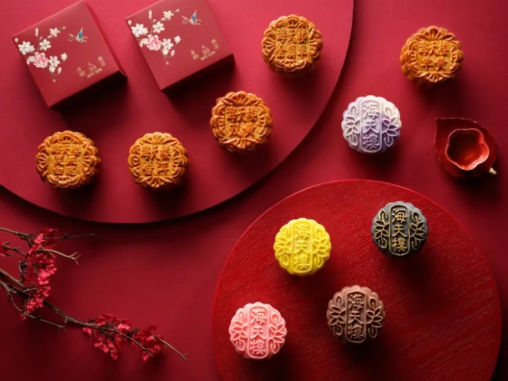 Multi-colored mooncakes arranged on red background