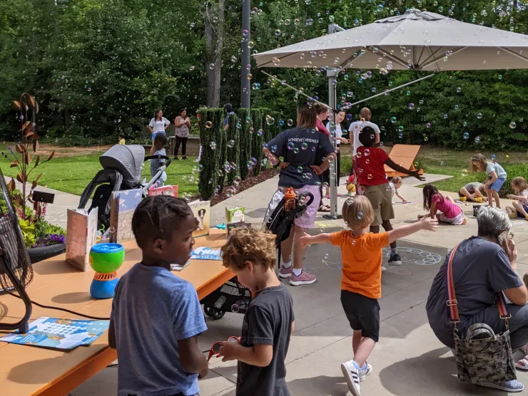 photo of a group of families celebrating on the back patio at Ballentine with bubbles and music