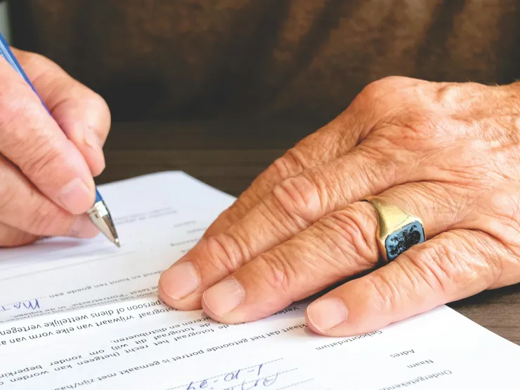 two hands signing a document