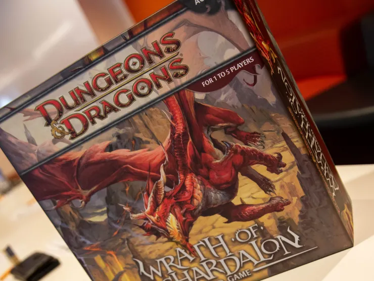 A photograph of the Duengons and Dragons boardgame and a character creation sheet on a white table. 